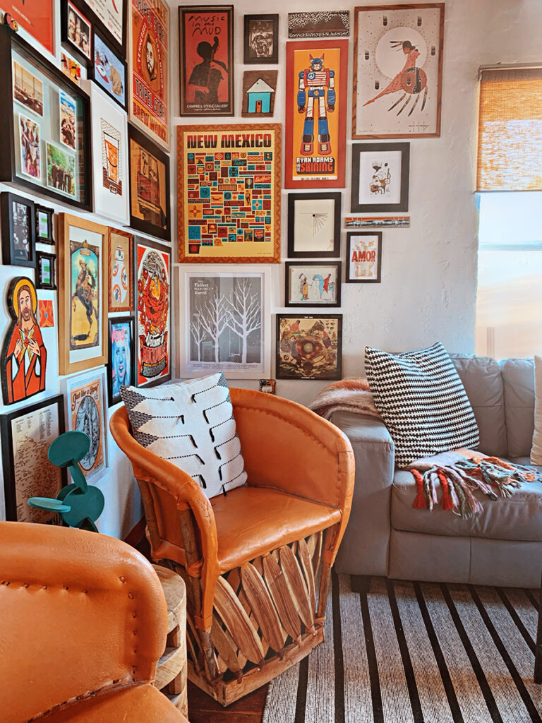 Corner gallery wall with Mexican equipale chairs in orange decor